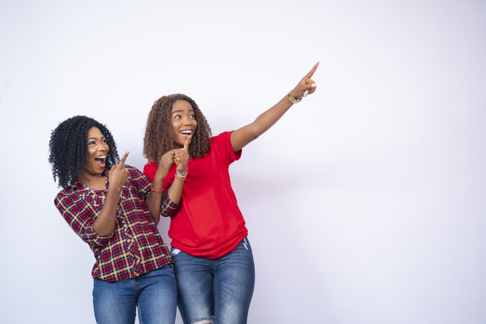 The two beautiful black woman pointing at something happy and excited
